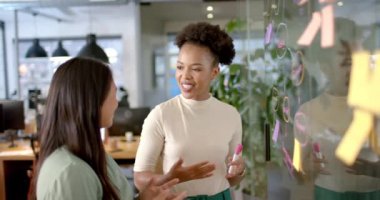 Genç Afrikalı Amerikalı kadın ofiste hareketli bir iş görüşmesi yapıyor. Ofis ayarları profesyonel ve işbirlikçi atmosferi geliştirir, yavaş çekim.