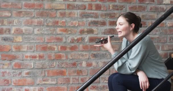 Kafkasyalı Genç Kadını Telefonuna Bir Sesli Mesaj Kaydediyor Merdivenlerde Oturuyor — Stok video
