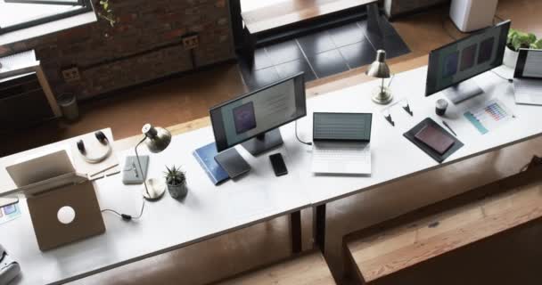 多台工作站 在商业环境中配备笔记本电脑 智能手机和台灯 环境意味着要有一个现代的 开放的办公室 有一个随意的 创造性的氛围 — 图库视频影像