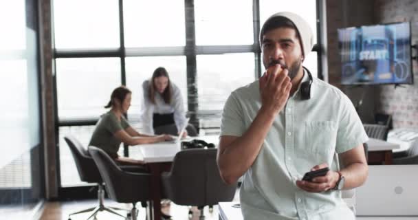 Young Asian Business Man Headphones His Neck Eats Apple Holding — Stock Video