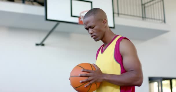 Afroamerikaner Hält Einen Basketball Der Hand Und Wirkt Entschlossen Einem — Stockvideo