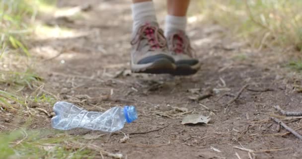 Una Persona Recoge Una Botella Plástico Mientras Camina Por Camino — Vídeo de stock