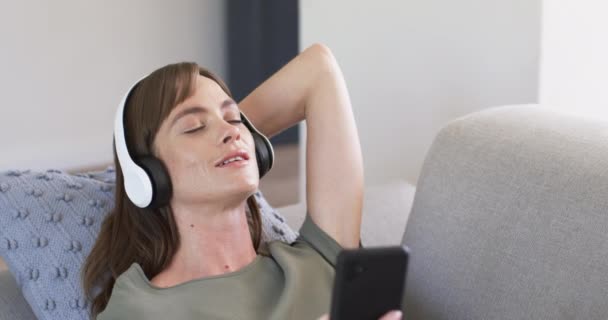 Caucasian Woman Enjoys Music Closed Eyes Wearing White Headphones She — Stock Video