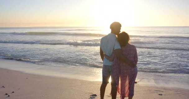 Biracial Couple Embraces Silhouetted Beach Sunset Copy Space Gentle Waves — Stock Video