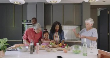 Çeşitli aileler mutfakta birlikte sağlıklı yemekler hazırlıyor, neşeli anları paylaşıyorlar. yemek, bağ, mutluluk, hazırlık, yaşam tarzı, sebzeler