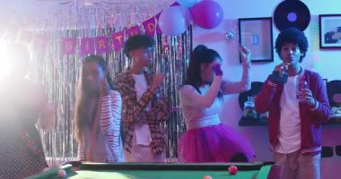 Doğum günü kızından sonra dans eden farklı arkadaşlar bilardo masasında pastayla öne çıkıyorlar. Kutlama, arkadaşlık, parti, gece hayatı, eğlence, sosyal, canlı