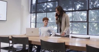 Konferans masasında dokümanları tartışıyorlar. Ofiste dizüstü bilgisayar kullanan çeşitli profesyoneller. İşbirliği, toplantı, takım çalışması, şirket, beyin fırtınası, çeşitli meslektaşlar