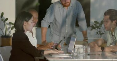 Ofis masasında iş birliği yapan, dizüstü bilgisayarlar kullanan ve fikirleri tartışan farklı bir takım. İşbirliği, takım çalışması, beyin fırtınası, üretkenlik, toplantı, iletişim