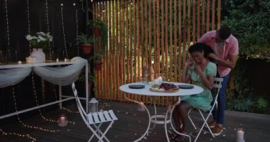 Çeşitli çiftler bahçede mum ve meyve tabağıyla romantik akşam yemeğinin tadını çıkarıyorlar. Aşk, yemek, kutlama, akşam, mum ışığı, atmosfer