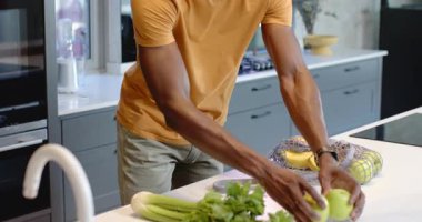 Sarı gömlekli Afro-Amerikalı adam mutfak tezgahında mikser dolduruyor, fotokopi odası. Modern, minimalist, yaşam tarzı, ev, çağdaş, sağlık, gündelik