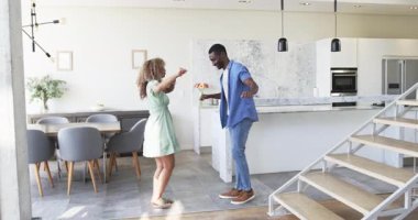 Modern ev mutfağında, yeşil elbiseli ve mermer adalı çeşitli dansçı çiftler el ele tutuşuyor. Romantik, mahremiyet, kutlama, yaşam tarzı, iç mekan, çağdaş, neşeli