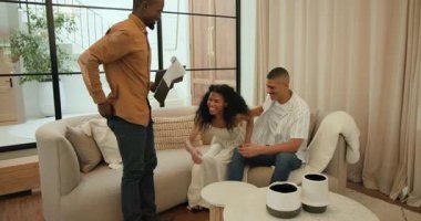 Mutlu, çeşitli bir çift evde arkadaşlarıyla kutlama yapıyor, ellerinde belgeler ve gülümsüyorlar. Kutlama, dostluk, mutluluk, kapalı alan, başarı, başarı