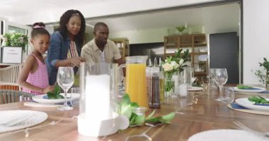 Çeşitli aileler evde birlikte vakit geçiriyorlar, gülümsüyorlar ve yemeğe hazırlanıyorlar. Beraberlik, yemek pişirme, evcil, bağlanma, mutluluk, neşe