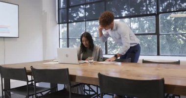 Ofisteki çeşitli meslektaşlar dizüstü bilgisayar ve akıllı telefon kullanarak projeyi tartışıyorlar. İş, takım çalışması, işbirliği, teknoloji, iletişim, şirket