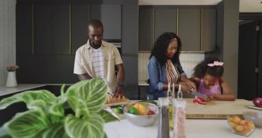 Çeşitli aileler modern mutfakta birlikte yemek hazırlıyor, gülümsüyor ve eğleniyorlar. Yemek pişirme, birliktelik, yaşam tarzı, bağlanma, mutluluk, aşçılık
