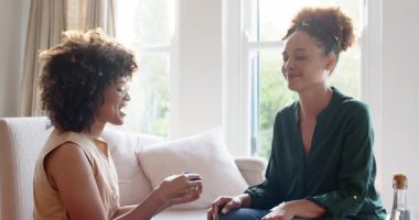 Gülümseyen kadın, evdeki rahat oturma odasındaki kanepede yüzükle partnerine evlenme teklif ediyor. Nişan, teklif, kutlama, aşk, bağlılık, ilişki