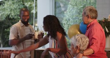 Çeşitli aileler evde kutlama yapıyor, şampanyayı neşe ve kahkaha ile açıyorlar. Kutlama, mutluluk, birliktelik, şenlik