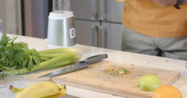 Afro-Amerikan bir adamın mutfak tezgahında yeşil elma dilimlemesi, fotokopi alanı. Sağlık, beslenme, tazelik, aşçılık, yaşam tarzı, sağlık, modern