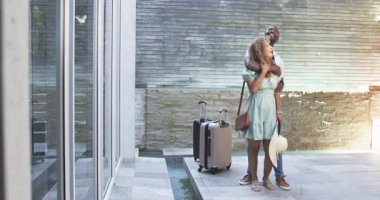 Terastaki su kanalında, bavulları yuvarlanan, kopyalama alanı olan Afrikalı Amerikalı çifti inceliyorum. Romantik, seyahat, açık hava, modern, boş zaman, yaşam tarzı, kentsel