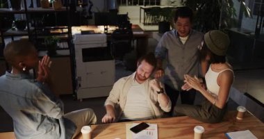 Çeşitli meslektaşlar, geceleri modern ofiste başarıyı kahveyle kutluyorlar. Takım çalışması, kutlama, işbirliği, iş, kahve molası, gece yarısı