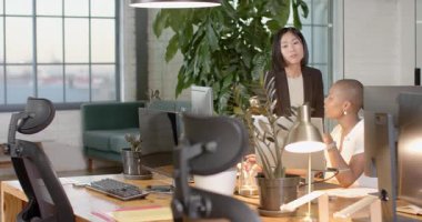 Ofis masasında çalışan çeşitli meslektaşlar bilgisayar ekranındaki verileri analiz ediyorlar. Takım çalışması, işbirliği, beyin fırtınası, analiz, üretkenlik, teknoloji