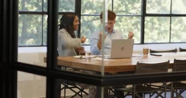 Ofisteki çeşitli meslektaşlar toplantı sırasında dizüstü bilgisayarla gülerken. İş, takım çalışması, işbirliği, işyeri, teknoloji, birlikte çalışma