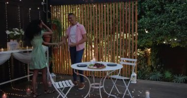 Bahçe akşamında gülümseyen ve eğlenen farklı çiftlerle romantik bir akşam yemeği. Romantizm, kutlama, bahçede, yemek, mum ışığı, mutluluk