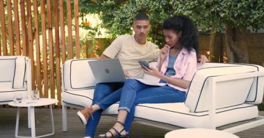 Bahçede dinlenirken, çeşitli çiftler birlikte boş vakitlerinde dizüstü bilgisayar ve akıllı telefon kullanıyorlar. Teknoloji, bağlantı, rahatlama, dijital cihazlar, yaşam tarzı