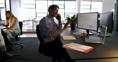 Genç profesyonel telefonda konuşuyor ve modern ofiste notlar alıyor. İş, iletişim, çalışma alanı, üretkenlik, teknoloji, çağdaş