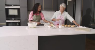 Mutfakta birlikte yemek yaparken, büyükanne ve çocuk neşeli anlar paylaşıyorlar. Çeşit çeşit aile, bağlılık, nesiller arası, ev, yemek