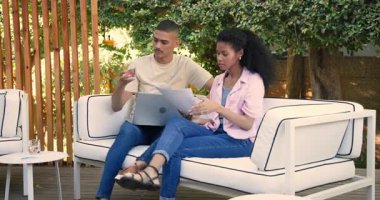 Verandada çeşitli çiftler bilgisayarla birlikte belgeleri inceliyor, odaklanmış ve meşgul. Takım çalışması, işbirliği, ev ofisi, dijital göçebe, iş dünyası, konsantrasyon