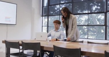 Çeşitli meslekdaşlar ofiste, modern konferans odasında dokümanları tartışıyor ve dizüstü bilgisayar kullanıyorlar. İşbirliği, takım çalışması, iş toplantısı, teknoloji, iletişim, ofis