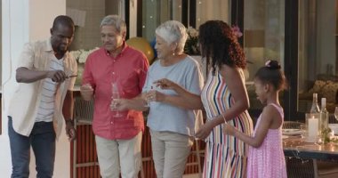 Çeşitli aileler dışarıda toplanmayı, güneşli bir günde evde içecekleri ve kahkahaları paylaşmayı seviyorlar. piknik, boş zaman, bağ, açık hava, mutluluk, yaz