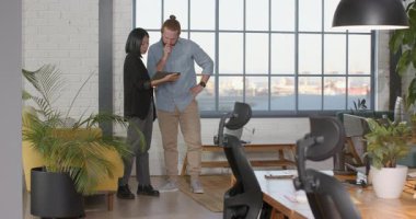 Meslektaşlarımız pencerenin yanındaki modern ofiste projeyi tartışıyor. Takım çalışması, işbirliği, şirket, teknoloji, yenilik, dijital