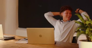 Meslektaşla başarı kutlaması, ofis masasında dizüstü bilgisayarlı bir kadın. Takım çalışması, işbirliği, başarı, çeşitlilik, teknoloji, profesyonel