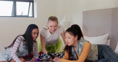 Yatakta eşarp ve mücevher sıralayan çeşitli bayan arkadaşlar, akıllı telefon beklenmedik bir mesaj gösteriyor. Arkadaşlık, gündelik, canlı, yaşam tarzı, aksesuarlar, ifade, etkileşim