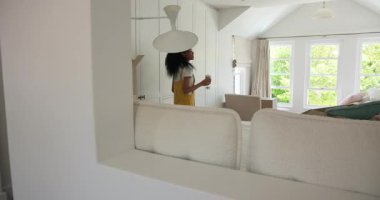 Çeşitli çiftler yeni evlerinin tadını çıkarırken, parlak oturma odalarında kutuları açıyorlar. Taşınma, taşınma, karton kutular, yaşam tarzı, oturma odası, ikamet