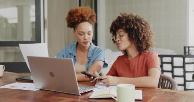 Evde çalışan, dizüstü bilgisayar kullanan ve telefonda tartışan lezbiyen çift. Uzaktan çalışma, takım çalışması, ortaklık, iletişim, ev ofisi, lgbtq