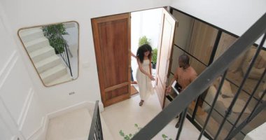 Çeşitli çiftler ev girişinde arkadaşlarıyla selamlaşıyor, gülümsüyor ve sohbet ediyorlar. Arkadaşlık, konukseverlik, sosyalleşme, mutluluk, etkileşim, dostluk