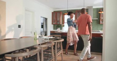 Modern mutfakta kucaklaşan farklı çiftler, evde özel bir anı sevgiyle kutluyorlar. Romantizm, mutluluk, yaşam tarzı, samimiyet, birliktelik, kutlama