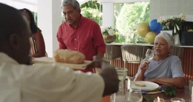 Çeşitli aileler evde yemek yiyip sohbet ederek masanın etrafında toplanıyor. Akşam yemeği, kutlama, birliktelik, konukseverlik, yaşam tarzı, kaynaşma