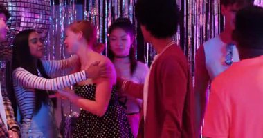 Çeşitli arkadaşlar doğum günü mumlarını izleyip pasta yakıyor ve disko topunun altında fıçıyla kutlama yapıyorlar. Şenlik, kutlama, gece hayatı, yoldaşlık, parti, aydınlanma, aksesuar