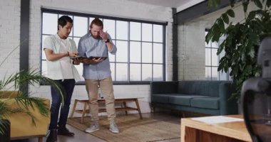 Modern ofis alanında tablet kullanarak iş stratejisini tartışan iki adam. takım çalışması, teknoloji, işbirliği, toplantı, çalışma alanı, dijital