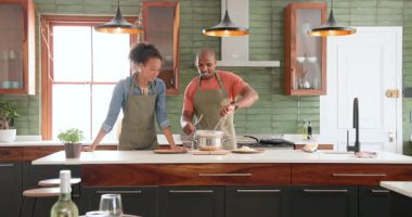 Modern mutfakta birlikte yemek pişiren, neşeli ifadeli makarna hazırlayan çeşitli çiftler. Mutfak, mutluluk, yemek, yaşam tarzı