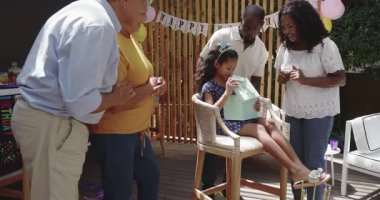 Doğumgününü dışarıda kutluyoruz, çocuk hediyesini büyük anne ve babayla birlikte açıyoruz. Çeşit çeşit aile, kutlama, hediye, mutluluk, nesil, neşe