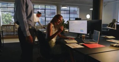 Muhtelif meslektaşlar ofis masasında bilgisayar ve çizelgelerle projeyi tartışıyor. İş, takım çalışması, işbirliği, toplantı, beyin fırtınası, analiz