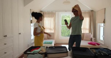 Çeşitli çiftler parlak yatak odasında bavullarını topluyor, birlikte tatile hazırlanıyorlar, evde. Seyahat, bagaj, tatil, turizm, boş zaman, hazırlık