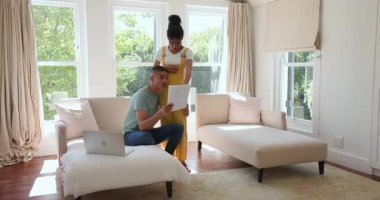 Evdeki çeşitli çiftler kanepede dizüstü bilgisayarla belgeleri tartışıyor. Tartışma, teknoloji, planlama, takım çalışması