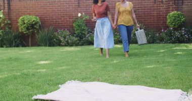 Bahçede piknik battaniyesinde oturmak, farklı lezbiyen çiftlerin sohbet etmesi. Arkadaşlar, eğlence, yoldaşlık, rahatlama, kaynaşma, açık hava.