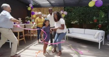 Doğumgününü dışarıda kutluyor, anneannenin bahçede kızını kucaklamasını alkışlıyor. Çeşitli aile, kutlama, mutluluk, nesiller, bağ, annelik